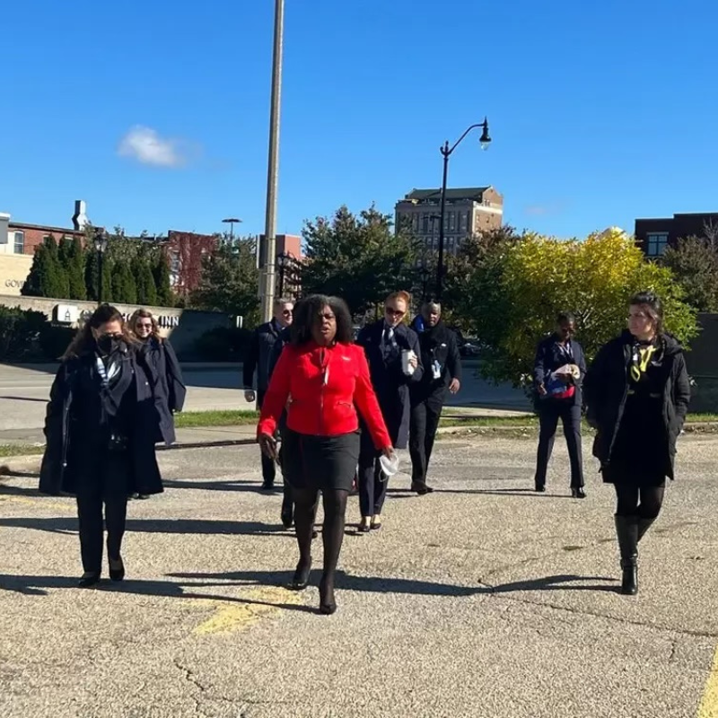 Union leader proudly marching with her newly formed coalition through the streets, having successfully changed legislation in Springfield to support their cause.